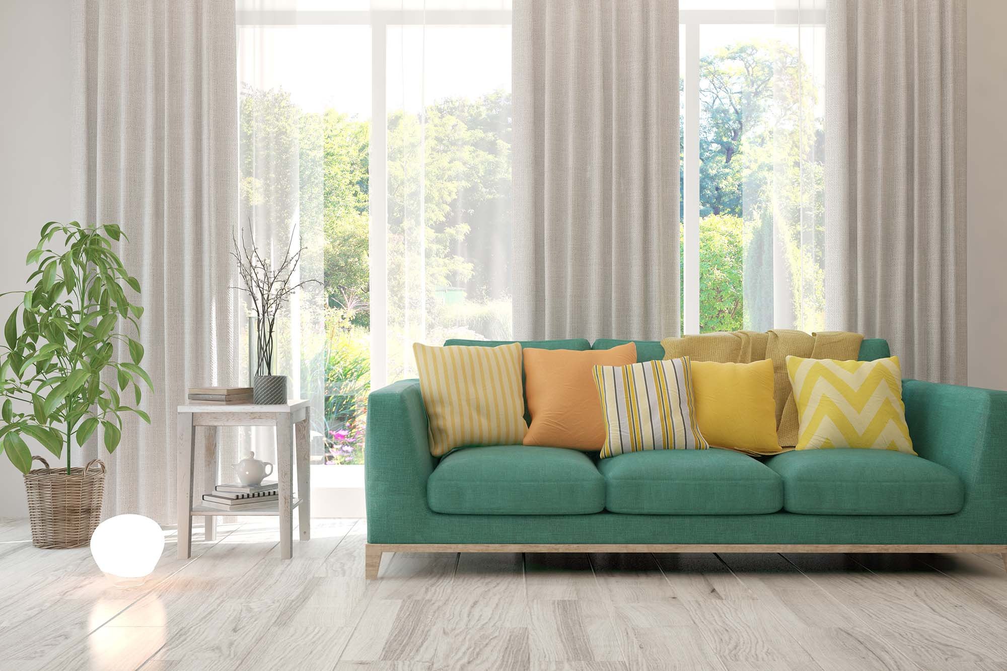 green couch with colourful cushions on tile floor